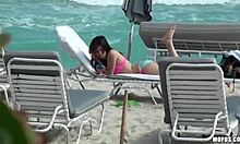 एक महिला समुद्र तट पर आराम करते हुए अपने पैरों की मालिश करती है।