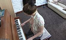 आकर्षक स्तन वाली एक चंचल श्यामला पियानो टॉपलेस खेलती हुई।